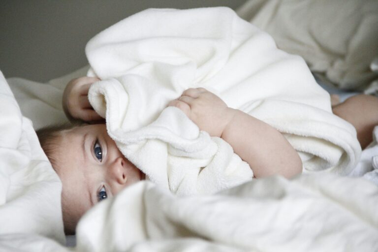 Young Baby Snuggling in a White Blanket