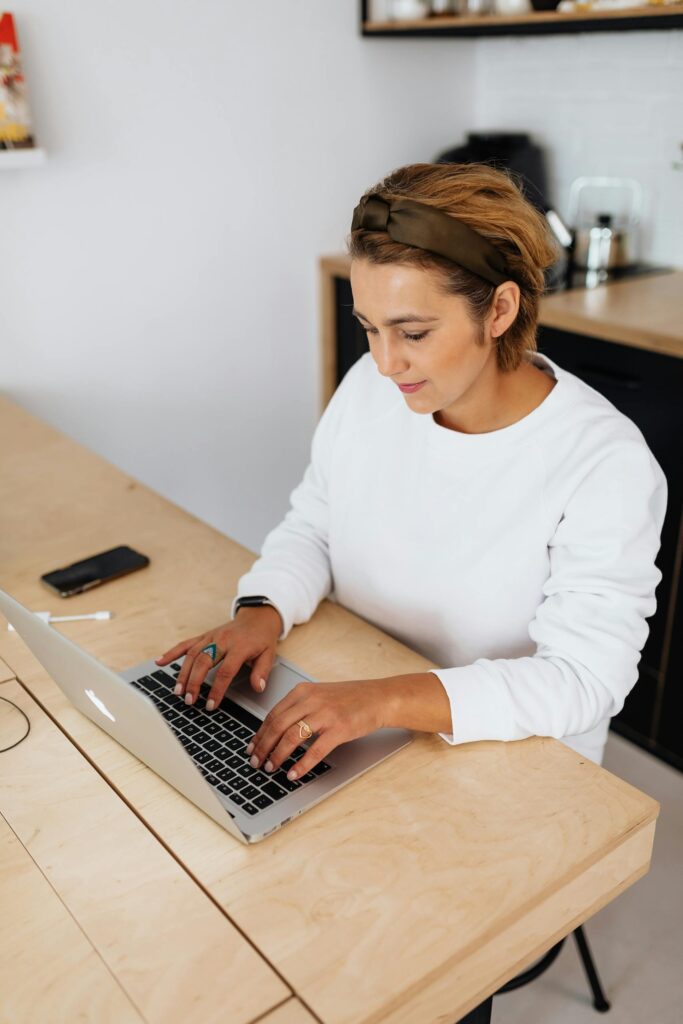 Writing your birth story Photo by Photo By: Kaboompics.com A woman with short hair writes her birth story on a laptop at a wooden desk, while looking focused.
