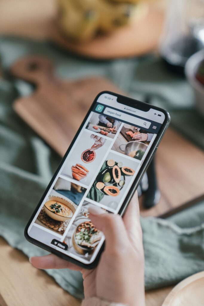 Browsing digital recipes Photo by Mike Jones Close-up of a hand holding a smartphone browsing food recipe images to improve meal planning habits.