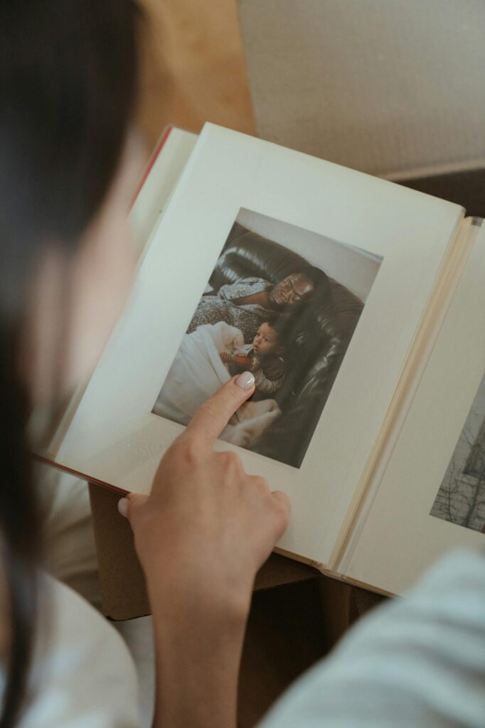 Personal Photo album Photo by cottonbro studio A person reminiscing through a family photo album, highlighting precious moments like honoring the completion of their breastfeeding journey.